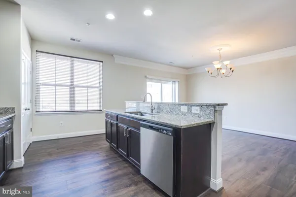 a view of living room kitchen with a sink and chandelier