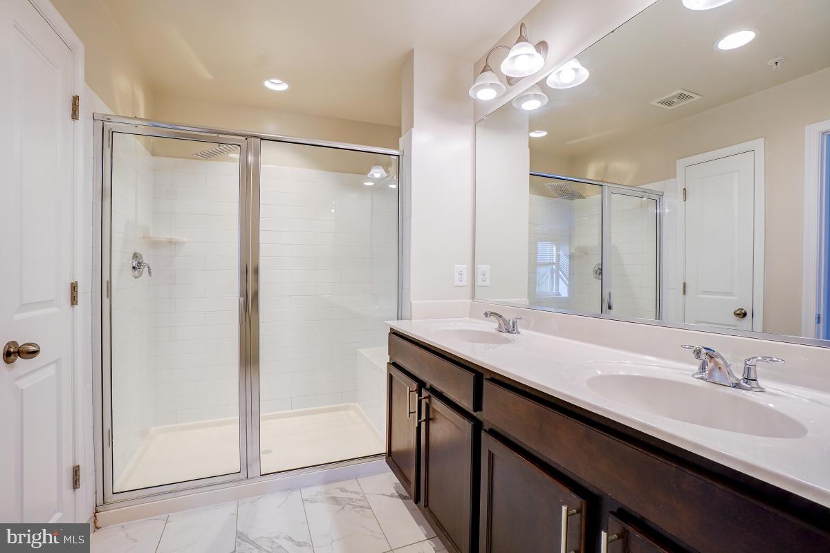 1709 Fieldstone Court Hanover, MD 21076 - Photo 21 of 30 a bathroom with double vanity sinks a toilet a shower a vanity and a mirror
