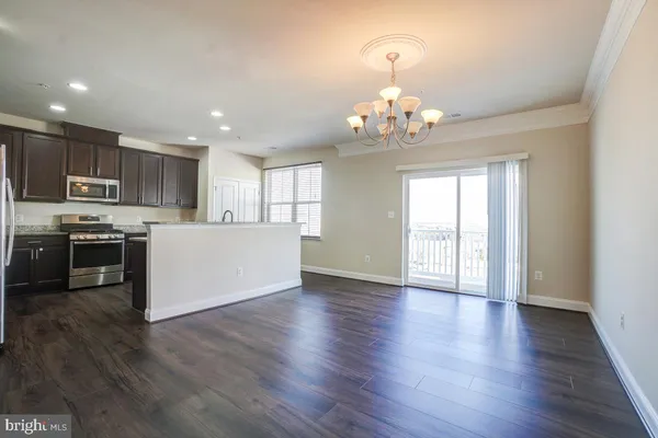 a view of a kitchen with granite countertop stainless steel appliances and wooden floor