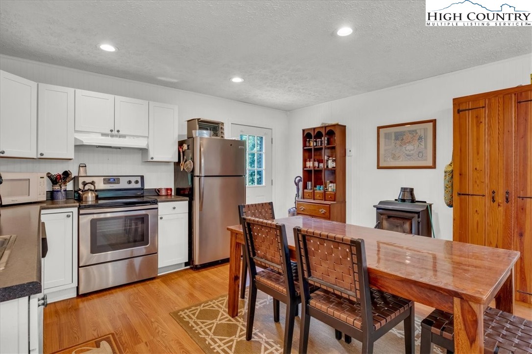 360 Fraser Road Sparta, NC 28675 - Photo 44 of 50 a kitchen with stainless steel appliances granite countertop a refrigerator a stove a sink a dining table and chairs