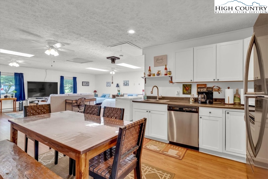 360 Fraser Road Sparta, NC 28675 - Photo 45 of 50 a kitchen with stainless steel appliances granite countertop a stove top oven a sink a dining table and chairs