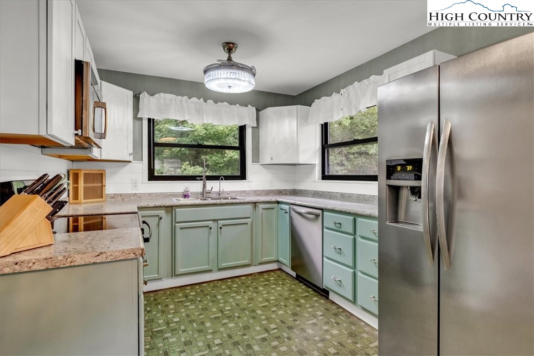 360 Fraser Road Sparta, NC 28675 - Photo 10 of 50 a kitchen with stainless steel appliances granite countertop a sink a stove and a refrigerator