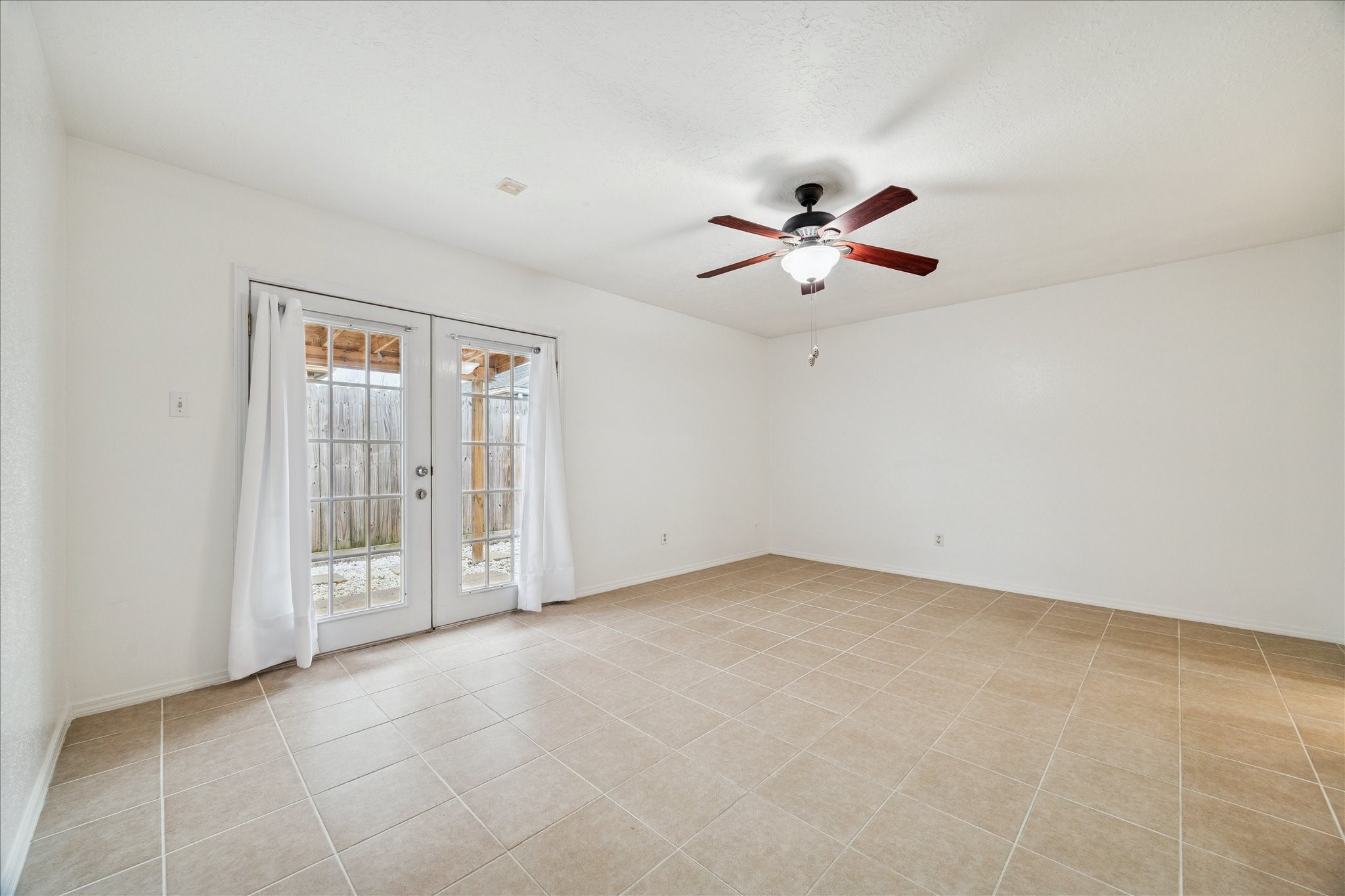 9306 Riverside Lodge Drive Houston, TX 77083 - Photo 16 of 20 an empty room with fan and glass door