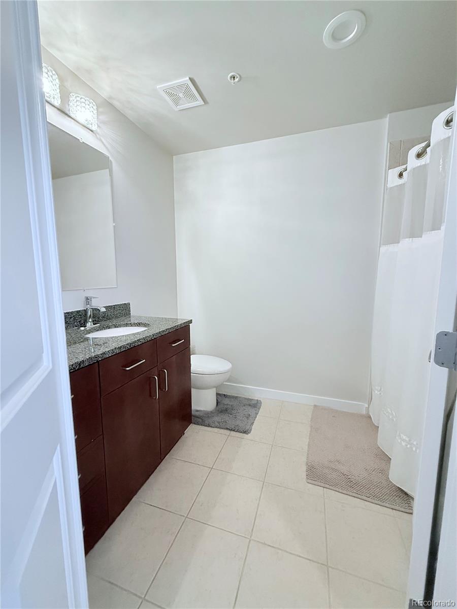 1700 Bassett Street, Unit 1412 Denver, CO 80202 - Photo 11 of 43 a room with a granite countertop sink a toilet and a mirror