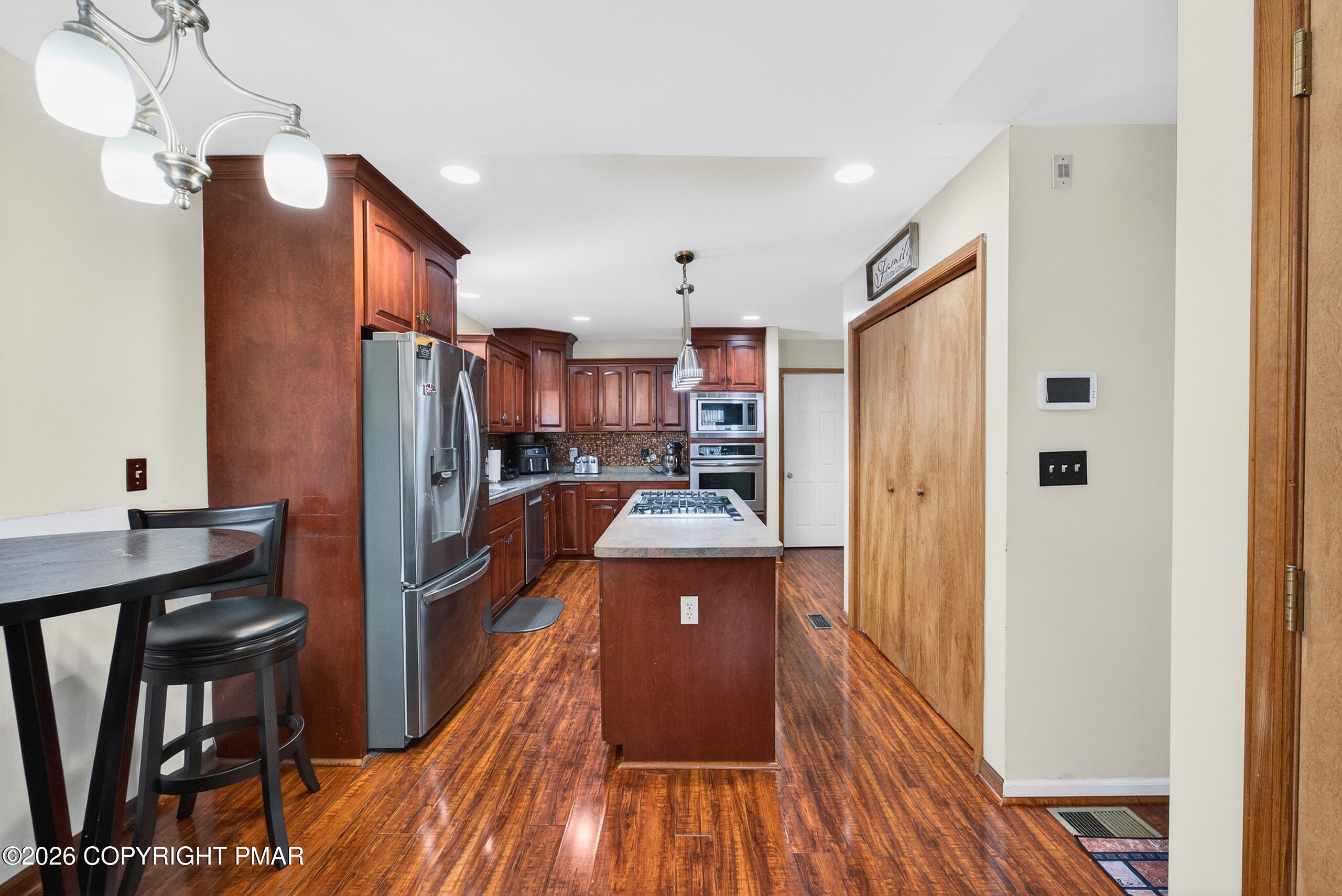 6293 Decker Road Bushkill, PA 18324 - Photo 16 of 38 a kitchen with stainless steel appliances granite countertop a refrigerator a stove top oven a chimney and a center island