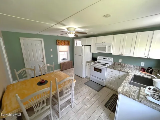 a kitchen with granite countertop a sink appliances and cabinets