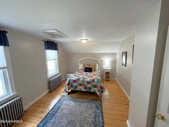 a bedroom with a bed and a mirror on dresser