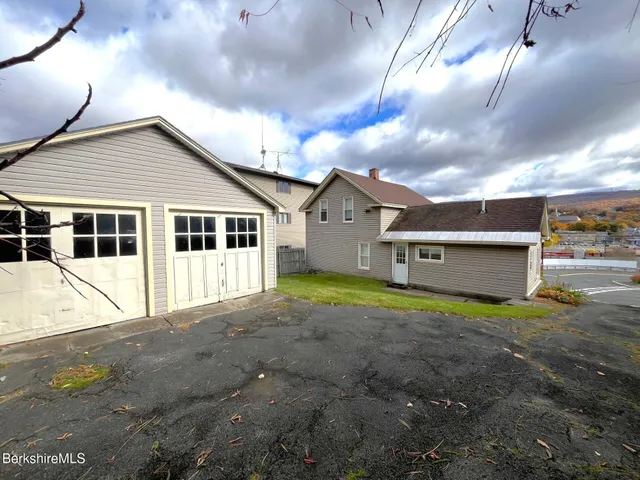 a view of backyard of house with green space