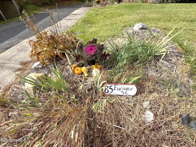 a sign that is sitting on a brick wall