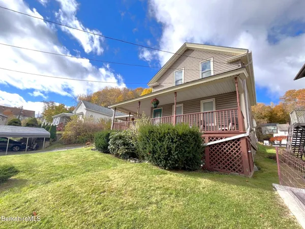 a view of a house with a yard and sitting area