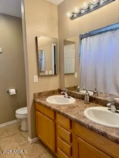 a bathroom with a granite countertop sink toilet and mirror