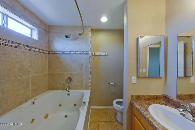 a bathroom with a tub a sink and mirror