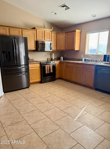 a kitchen with stainless steel appliances granite countertop a stove a sink dishwasher a refrigerator and cabinets