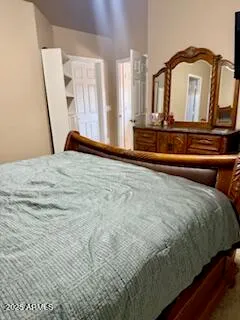 a bedroom with a bed a mirror and dresser