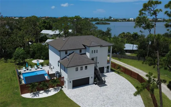 an aerial view of a house with a garden and lake view