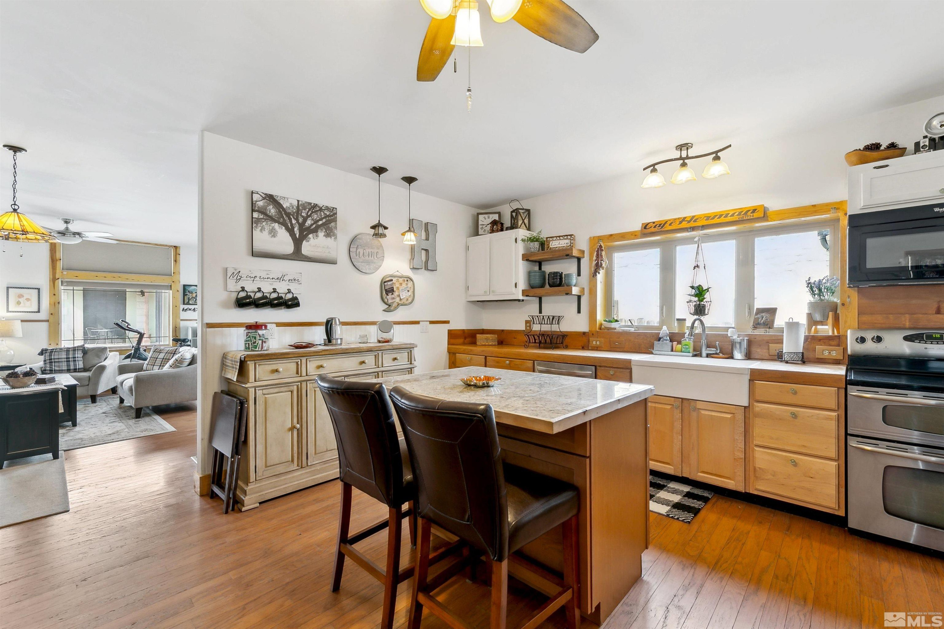 55 Main Street Dayton, NV 89403 - Photo 11 of 23 a kitchen with stainless steel appliances a stove a sink dishwasher and white cabinets with wooden floor