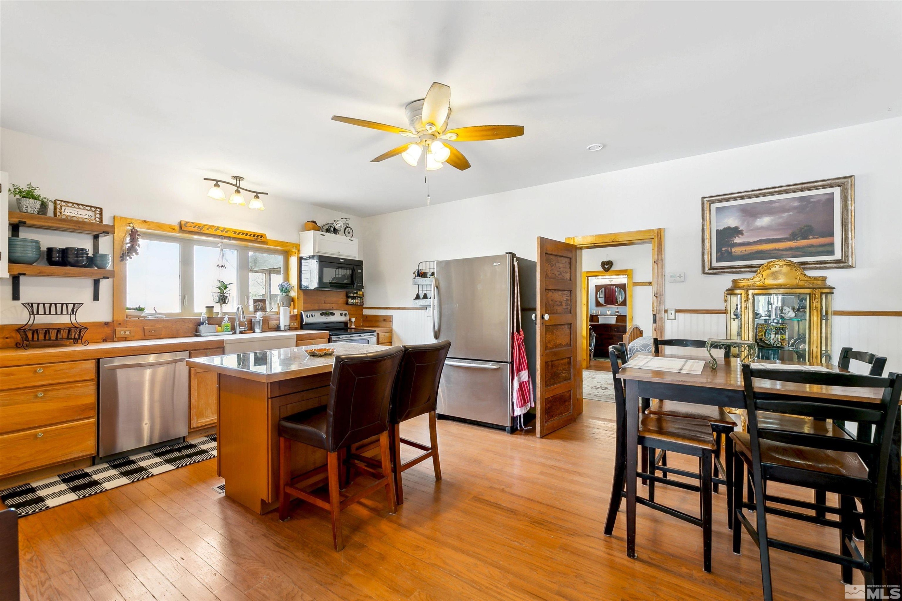 55 Main Street Dayton, NV 89403 - Photo 9 of 23 a dining room with stainless steel appliances a dining table and chairs with wooden floor