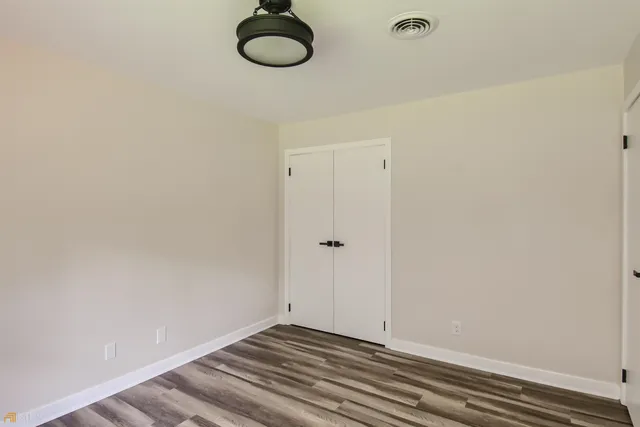 a view of a room with a fan and wooden floor