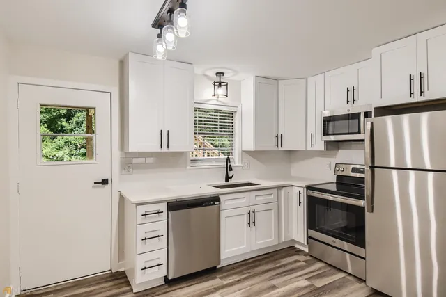 a kitchen with a sink stainless steel appliances and window