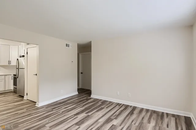 a view of a room with wooden floor and a hallway