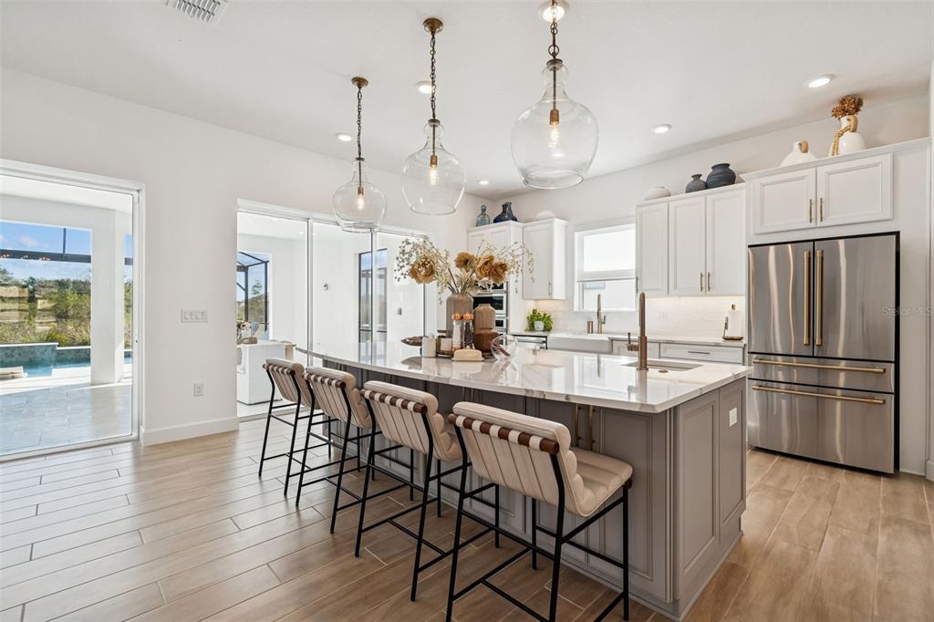 4848 Rosatti Road Wesley Chapel, FL 33543 - Photo 23 of 90 a kitchen with stainless steel appliances granite countertop a kitchen island a stove a refrigerator a oven a sink with a dining table and chairs
