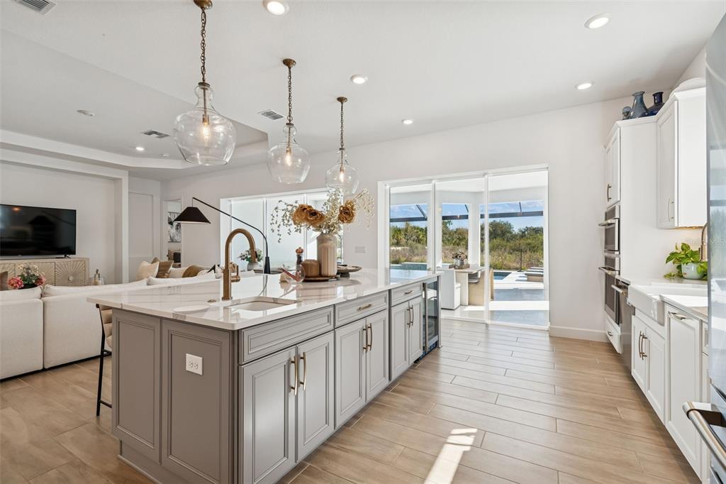4848 Rosatti Road Wesley Chapel, FL 33543 - Photo 27 of 90 a large kitchen with stainless steel appliances kitchen island a large counter top a sink a stove and a wooden floors