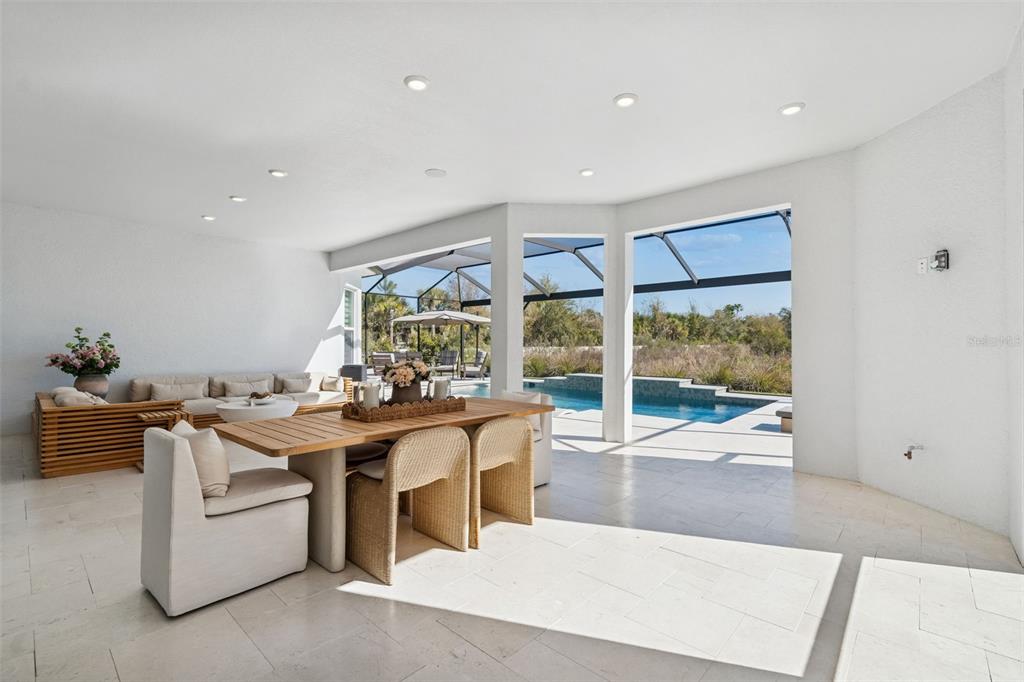 4848 Rosatti Road Wesley Chapel, FL 33543 - Photo 54 of 90 a living room with stainless steel appliances kitchen island granite countertop a table and chairs in it