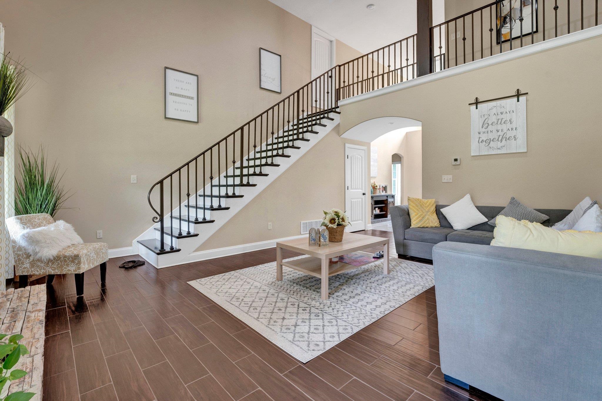 3270 Rast Road Millington, TN 38053 - Photo 9 of 40 Living area featuring arched walkways, wood tiled floors, a high ceiling, and stairs