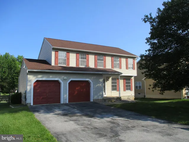 a front view of a house with a garden and garage