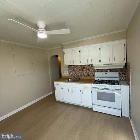 a kitchen with cabinets appliances and a wooden floor