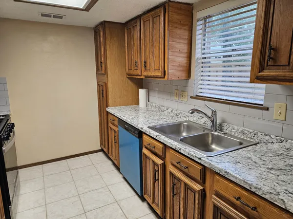 a kitchen with granite countertop a sink and a stove