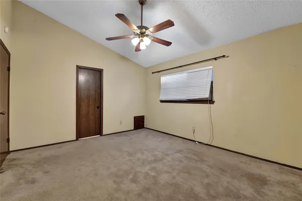 an empty room with windows and fan