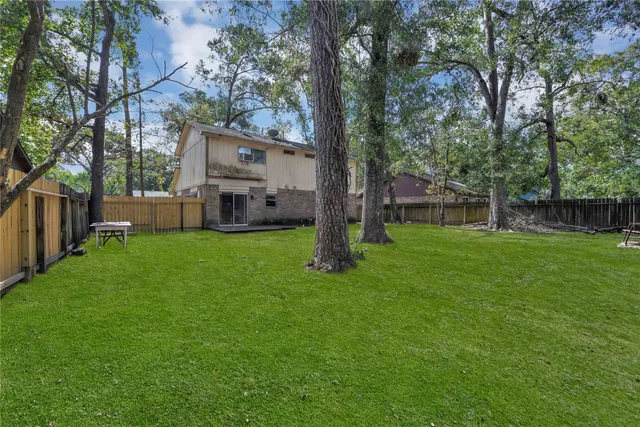 a view of a house with backyard and a tree