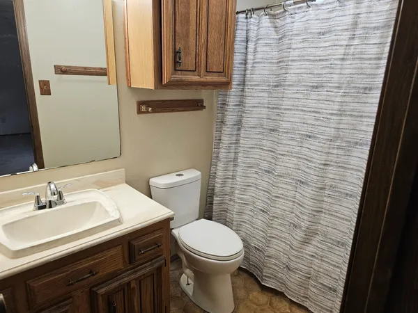 a bathroom with a sink a toilet and a mirror