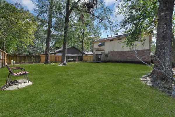 a view of a house with backyard and a tree