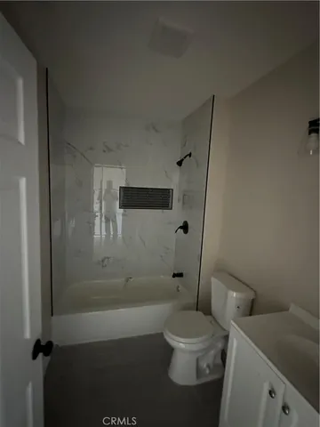 a white toilet sitting next to a bath tub and a shower