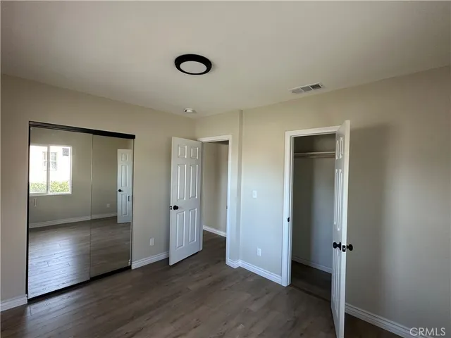 an empty room with wooden floor and a window