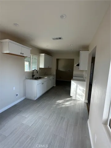 a view of a kitchen with wooden floor and electronic appliances