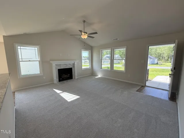 a view of empty room with fireplace and fan