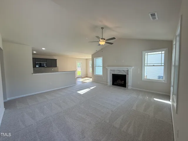 an empty room with windows and fireplace