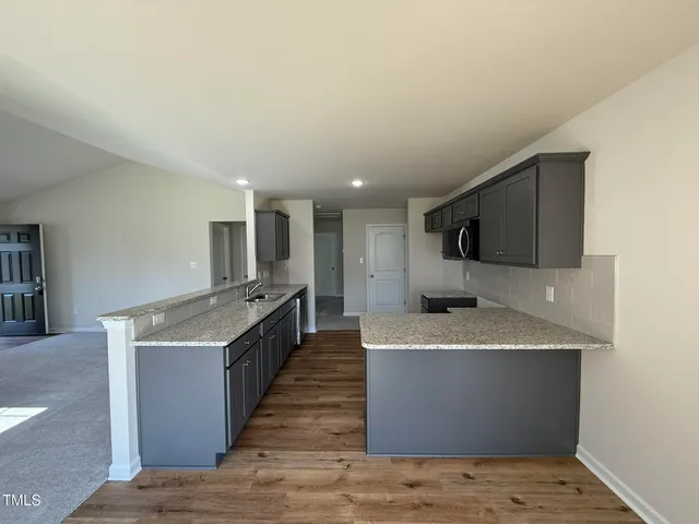 a large kitchen with stainless steel appliances a stove top oven