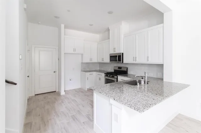 a kitchen with stainless steel appliances granite countertop a sink refrigerator and cabinets