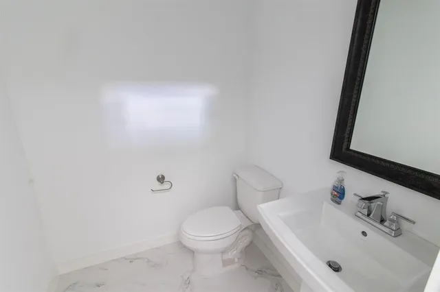 a white toilet sitting next to a bathroom sink