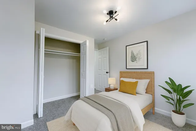 a bedroom with a bed and a potted plant