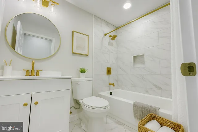 a bathroom with a toilet a sink a mirror and bathtub