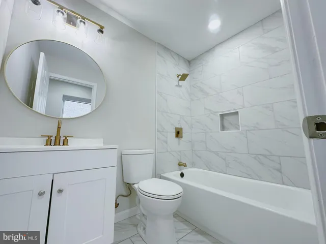 a bathroom with a toilet sink a bathtub and a mirror