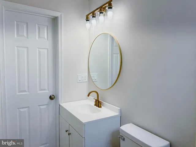 a bathroom with a sink a toilet and a mirror