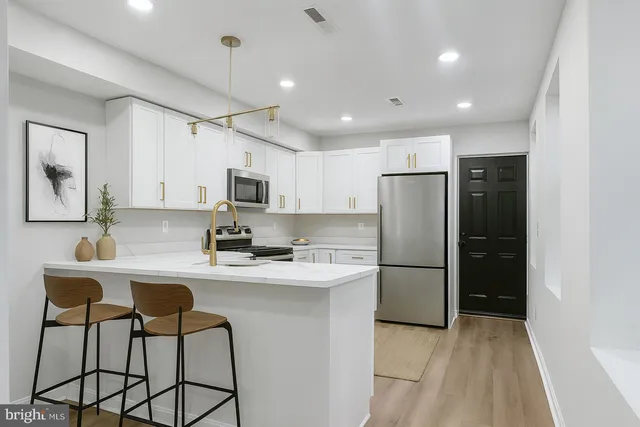 a kitchen with stainless steel appliances a refrigerator stove microwave and cabinets