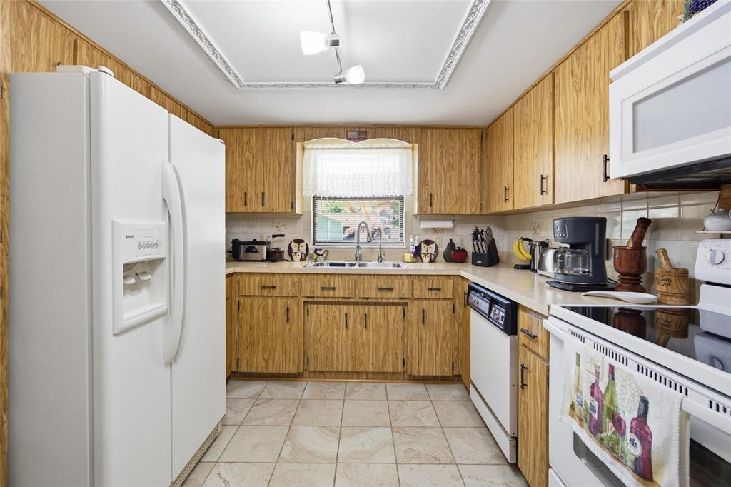 5141 East Backner Lane Inverness, FL 34452 - Photo 13 of 31 a kitchen with a refrigerator a sink and cabinets