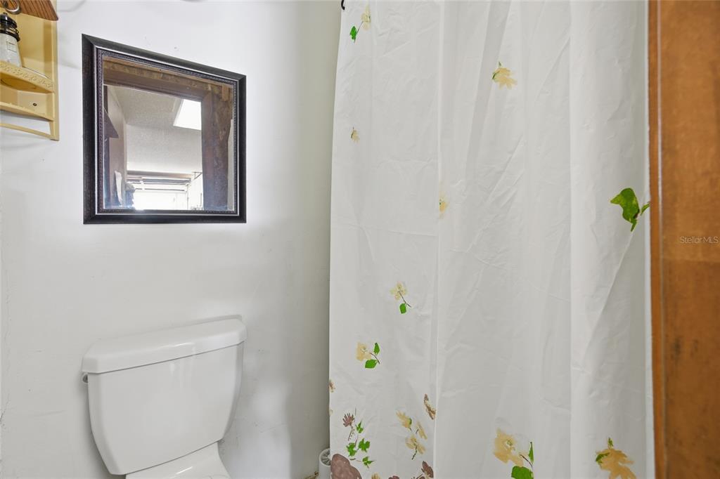 5141 East Backner Lane Inverness, FL 34452 - Photo 20 of 31 a bathroom with a toilet and a shower curtain